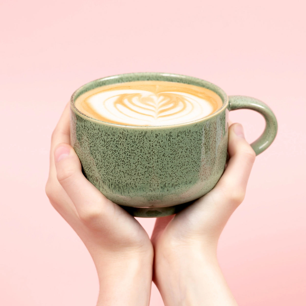 A green speckled ceramic mug. 
