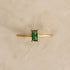 A gold band ring with green emerald cz stone in the center. 