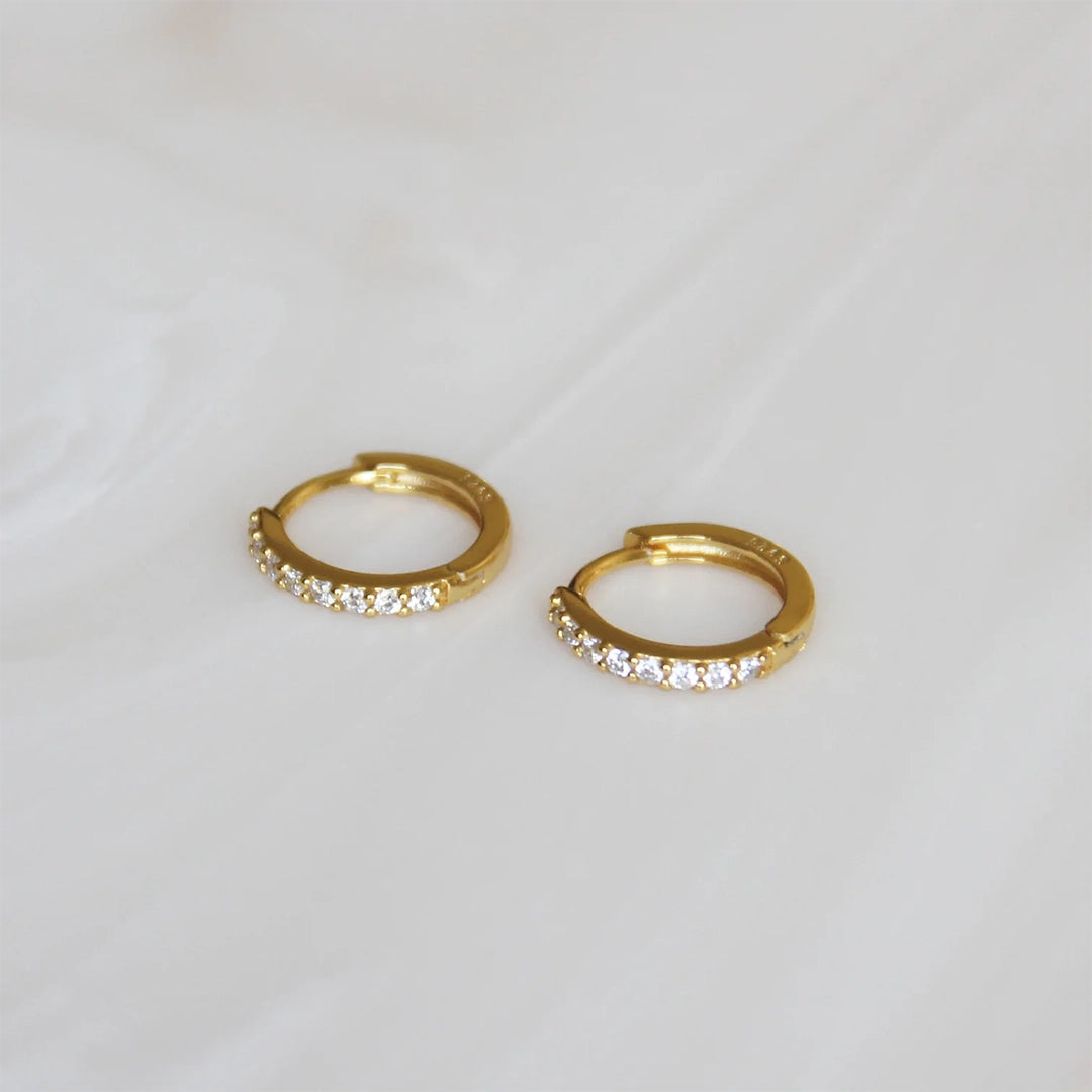 Gold huggie hoops with small CZ stones.