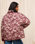 A maroon and white floral print quilted jacket. 