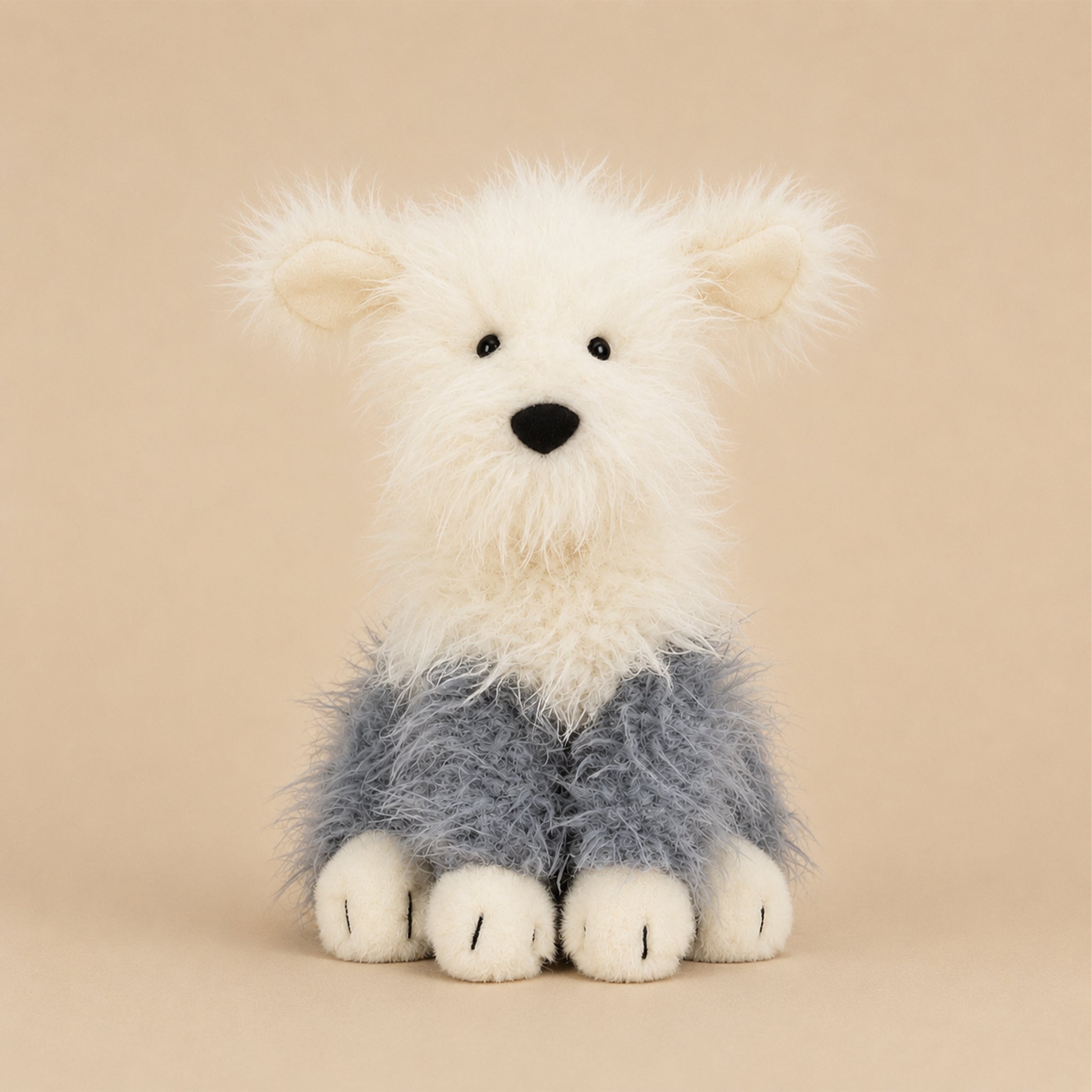 A cream and grey sheepdog shaped stuffed animal toy. 