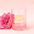 A light pink, clear tumbler glass with gold text that reads, "Extra Naughty".