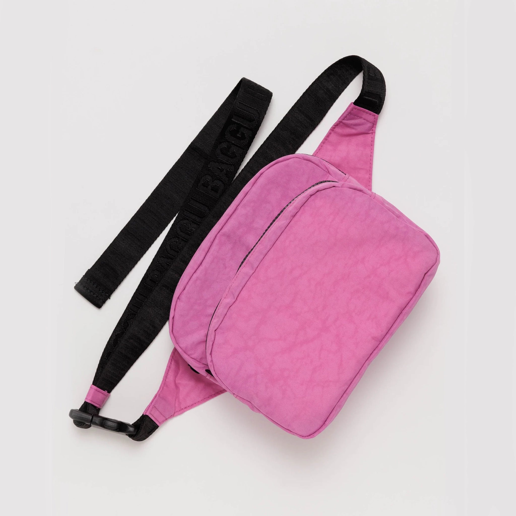 On a white background is a bright pink fanny pack with a black strap. 
