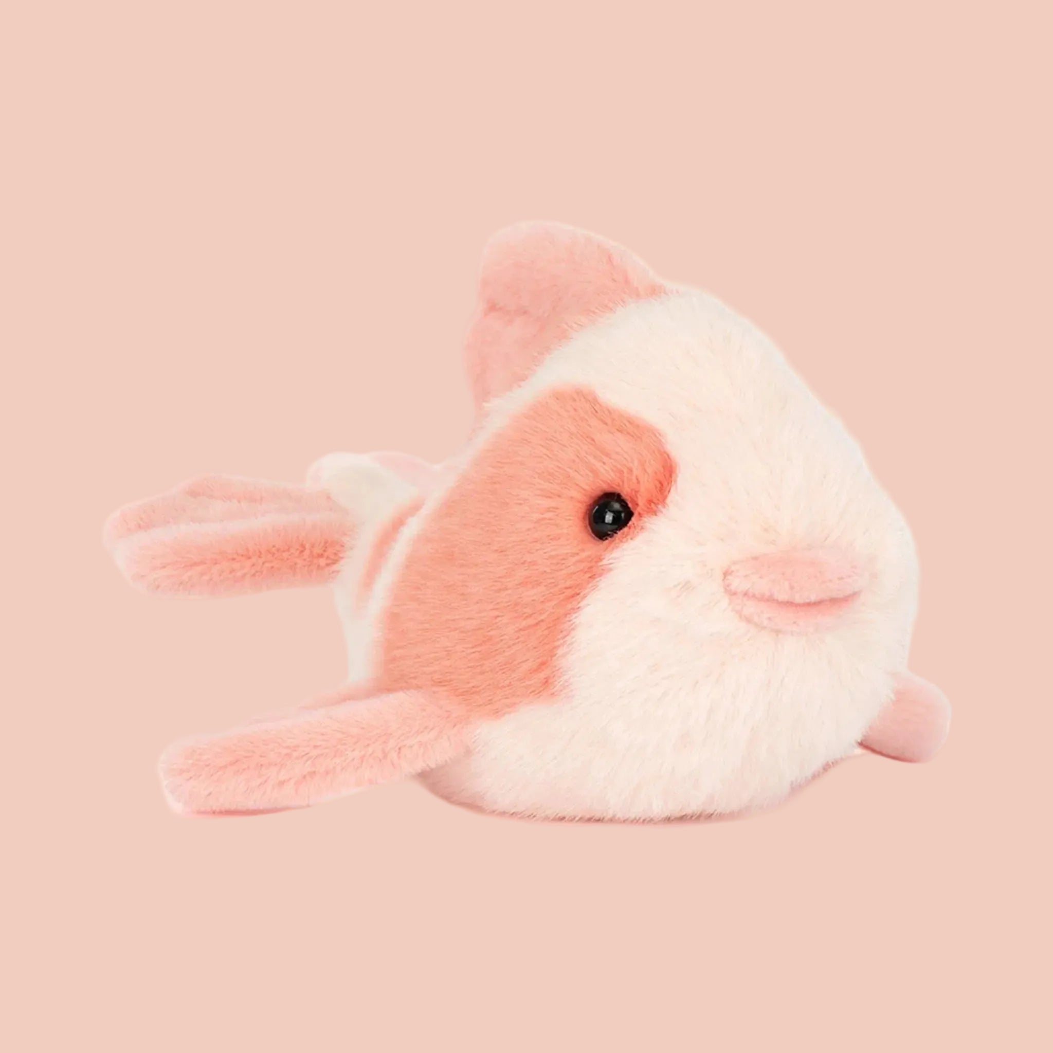 Plush toy fish with pink and white colors on a white background