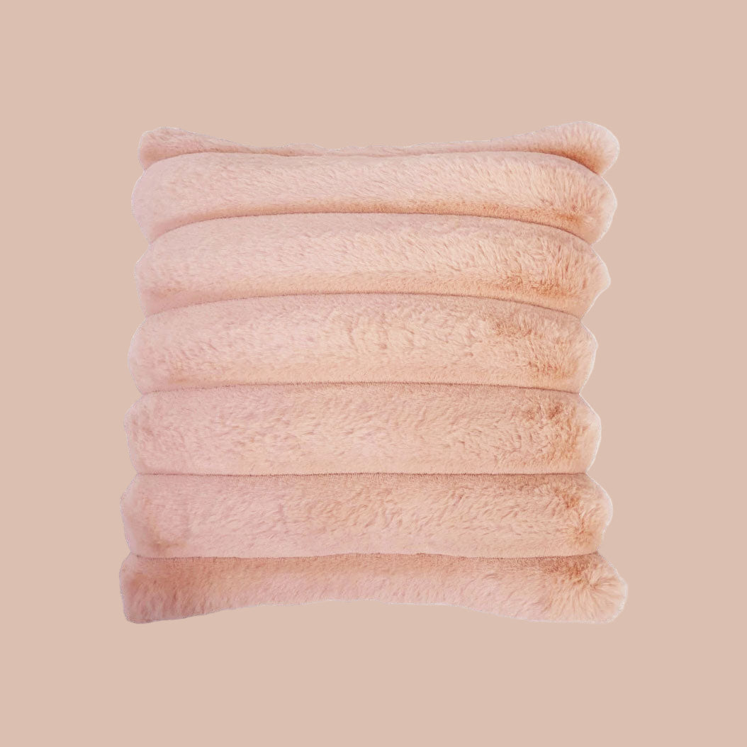 A light pink faux fur square pillow. 
