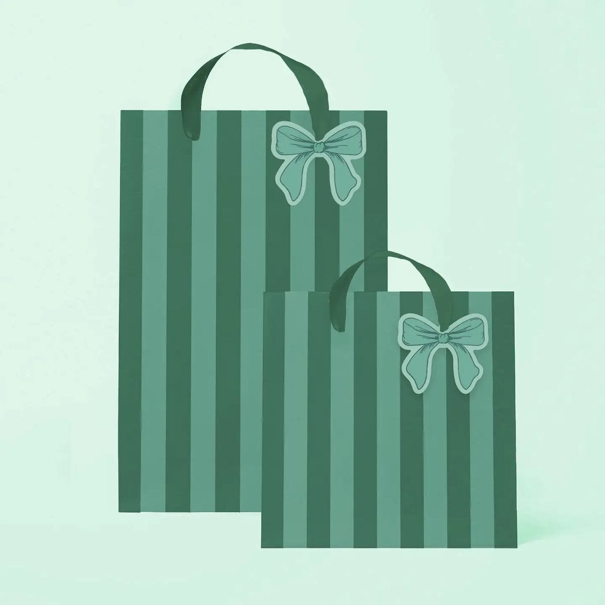 Two green striped gift bags with dark green handles and a light green bow illustration on the front, shown on a pale mint green background.