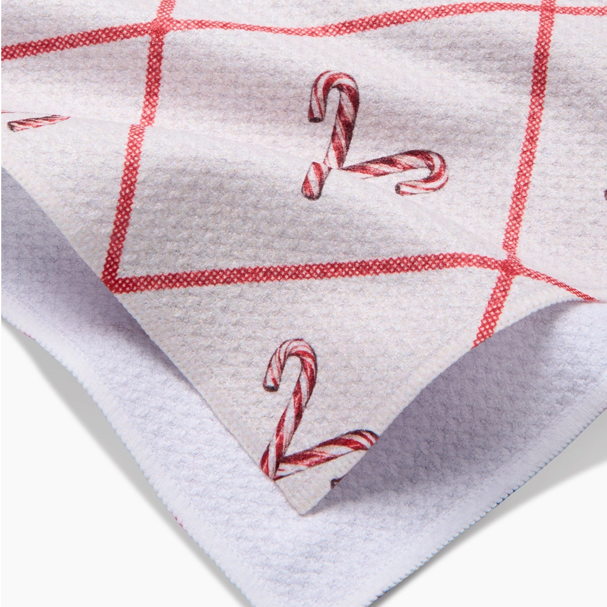 A white tea towel with a red and white candy cane pattern. 
