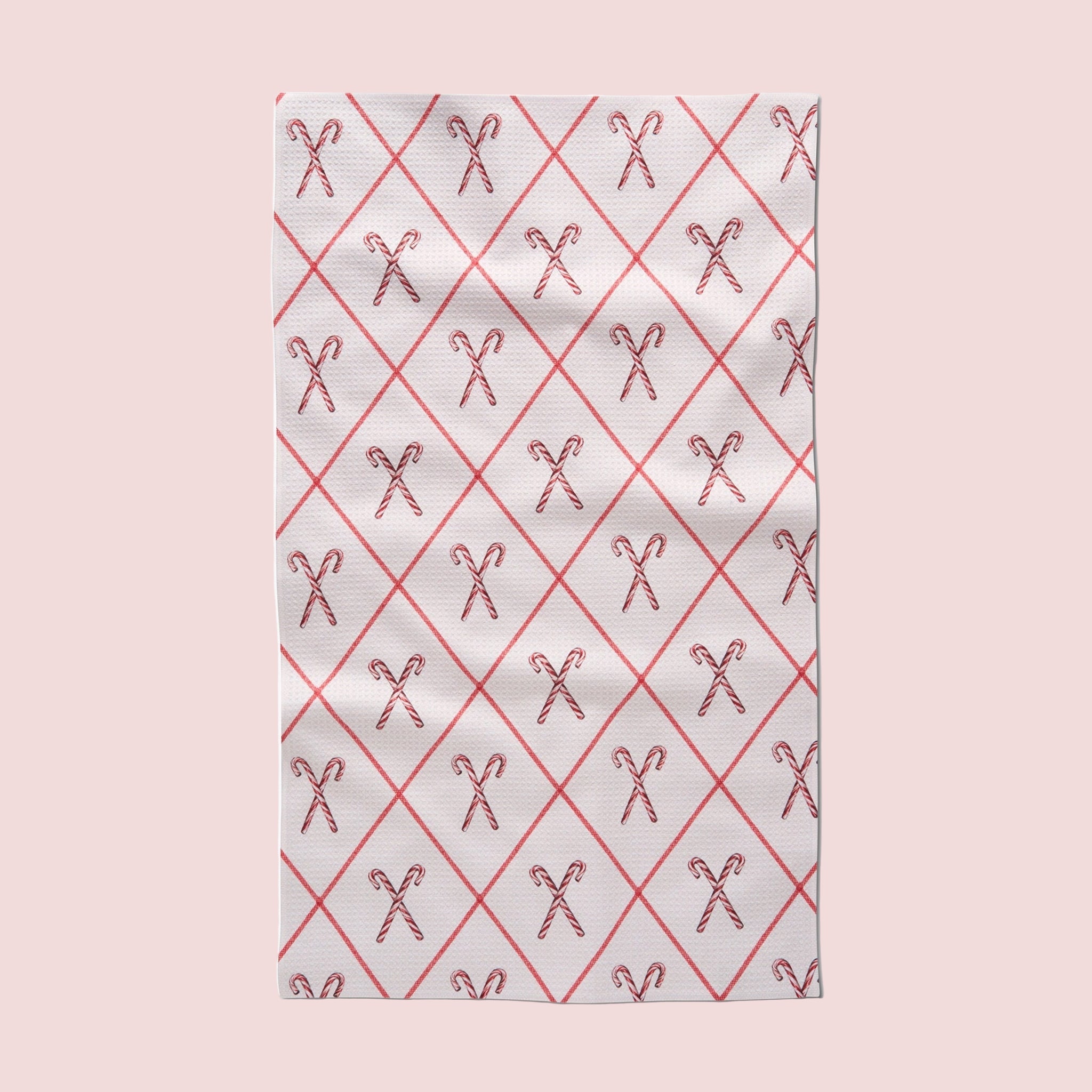 A white tea towel with a red and white candy cane pattern. 