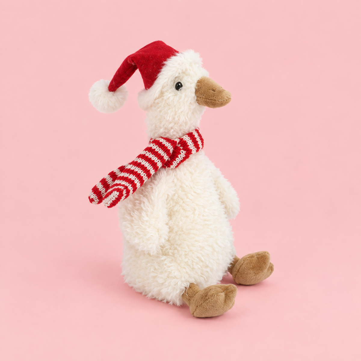 a white goose shaped plush toy with a red santa hat and white and red scarf. 