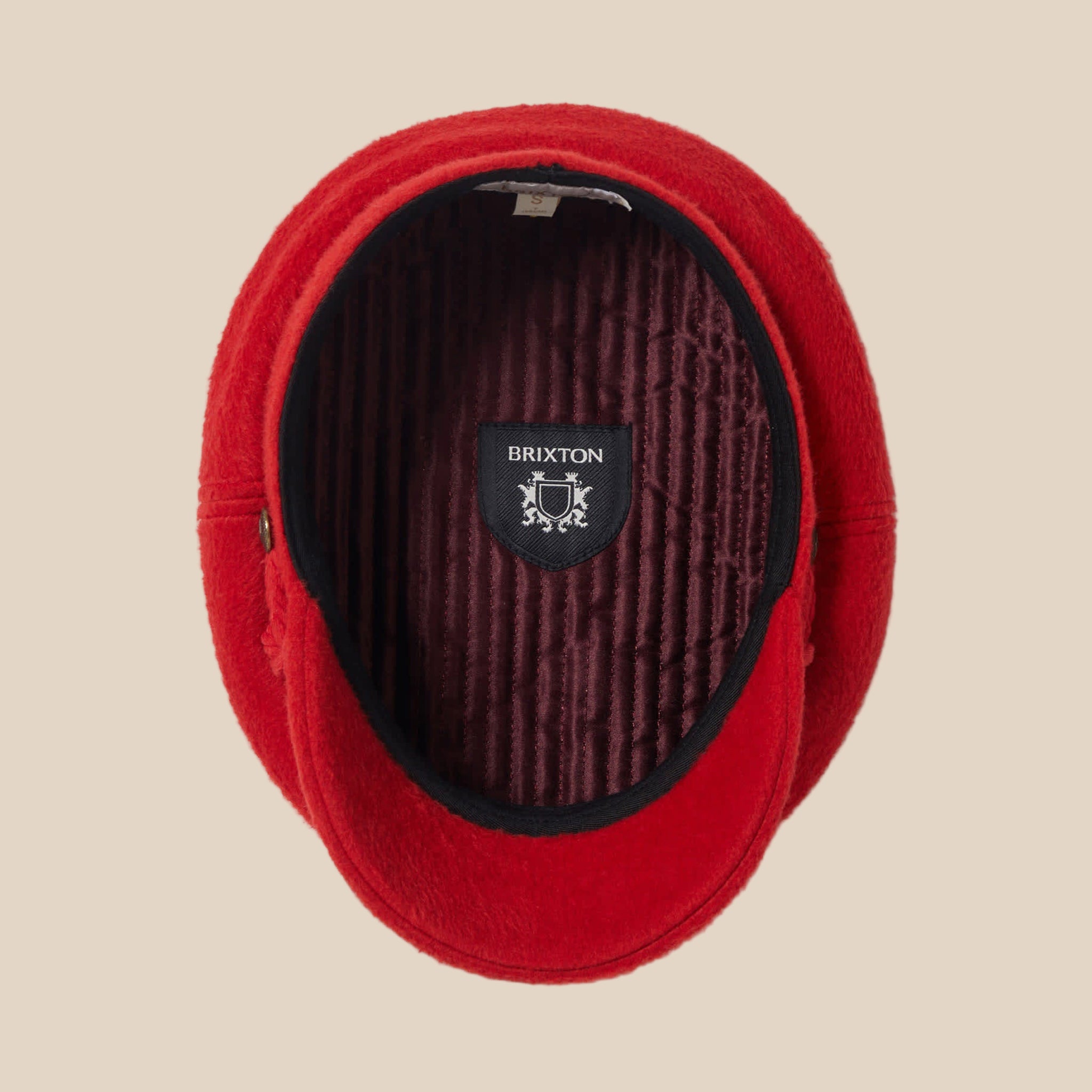 A red hat / cap with an interior label that reads, "Brixton". 
