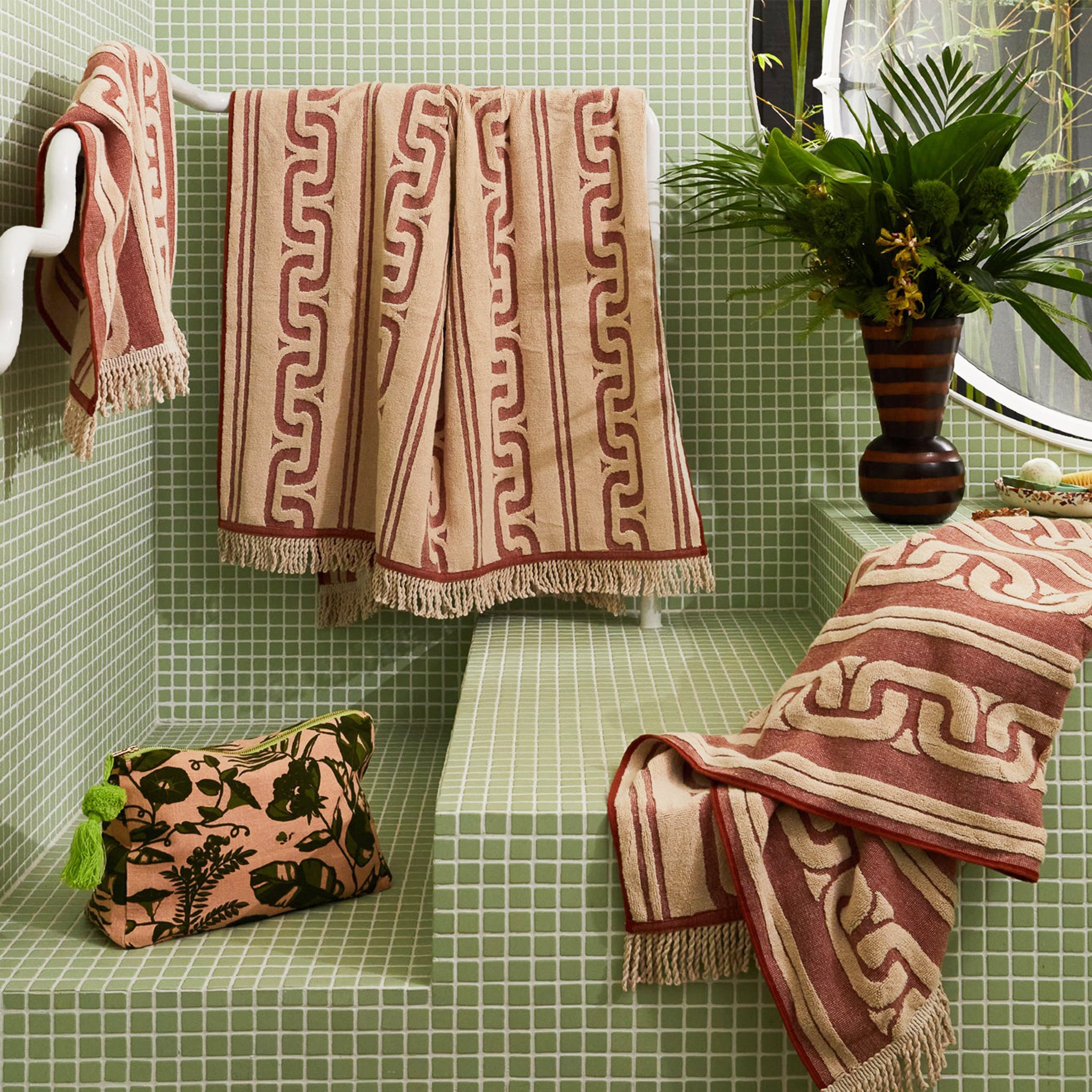 A brown and dark brown bath towel with a wavy design and fringe edge.