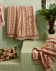 A brown and dark brown bath towel with a wavy design and fringe edge.