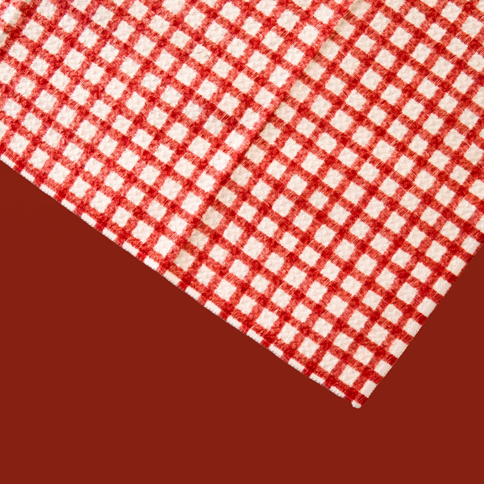 A red and ivory plaid print one sided kitchen towel. 