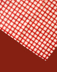 A red and ivory plaid print one sided kitchen towel. 