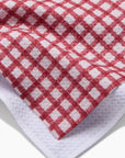 A red and ivory plaid print one sided kitchen towel. 