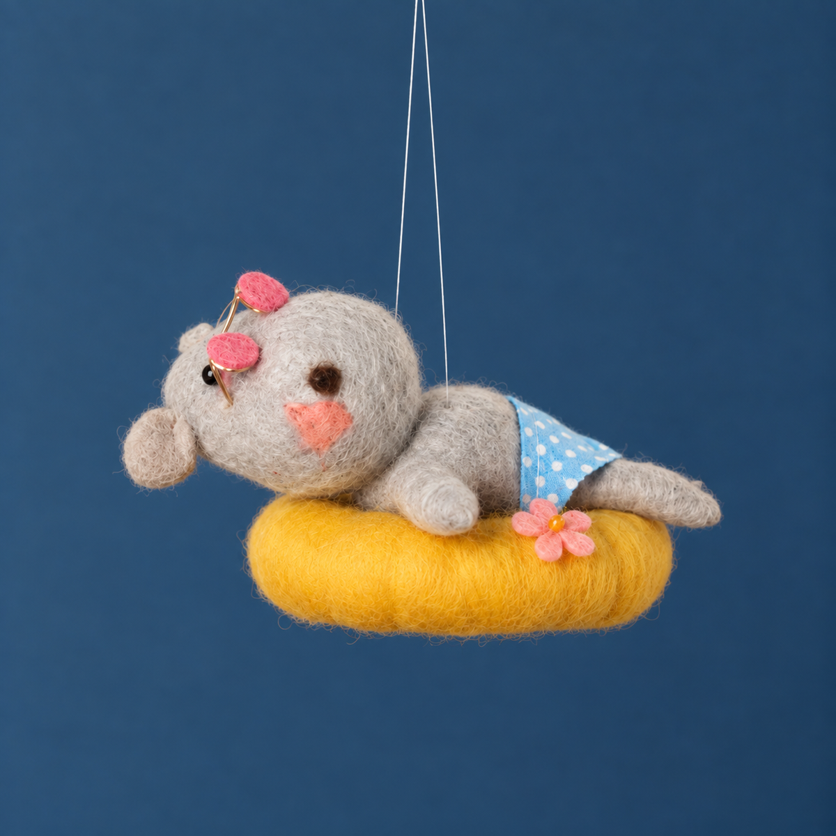a felt hippo shaped ornament on a yellow pool tube. 