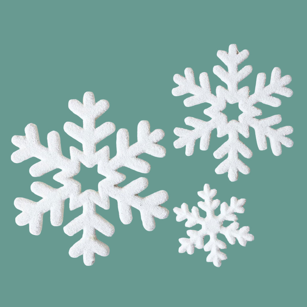 White snowflake-shaped decorations on a green background