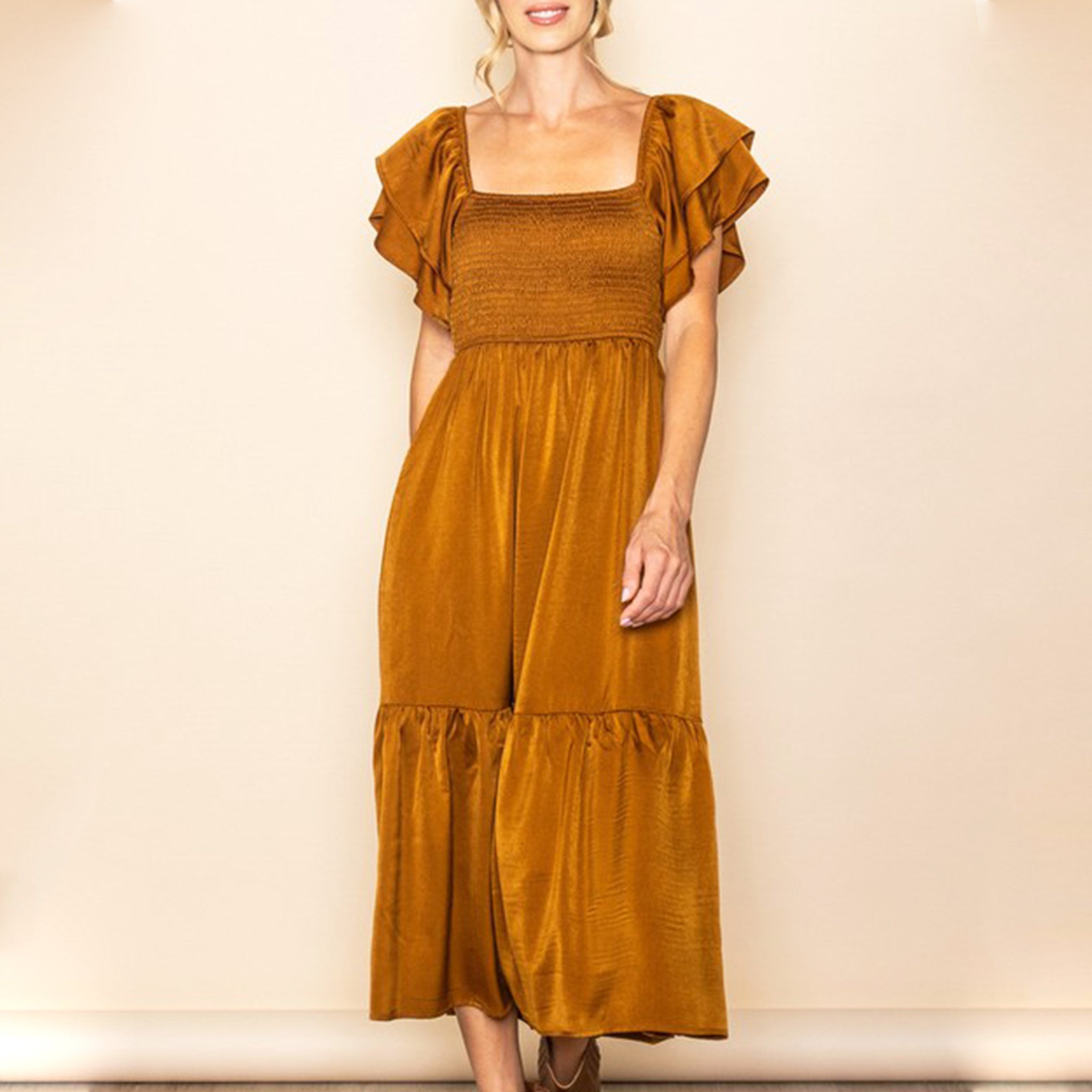 A copper satin dress with a smocked bodice, flutter sleeves and a tiered skirt bottom. 