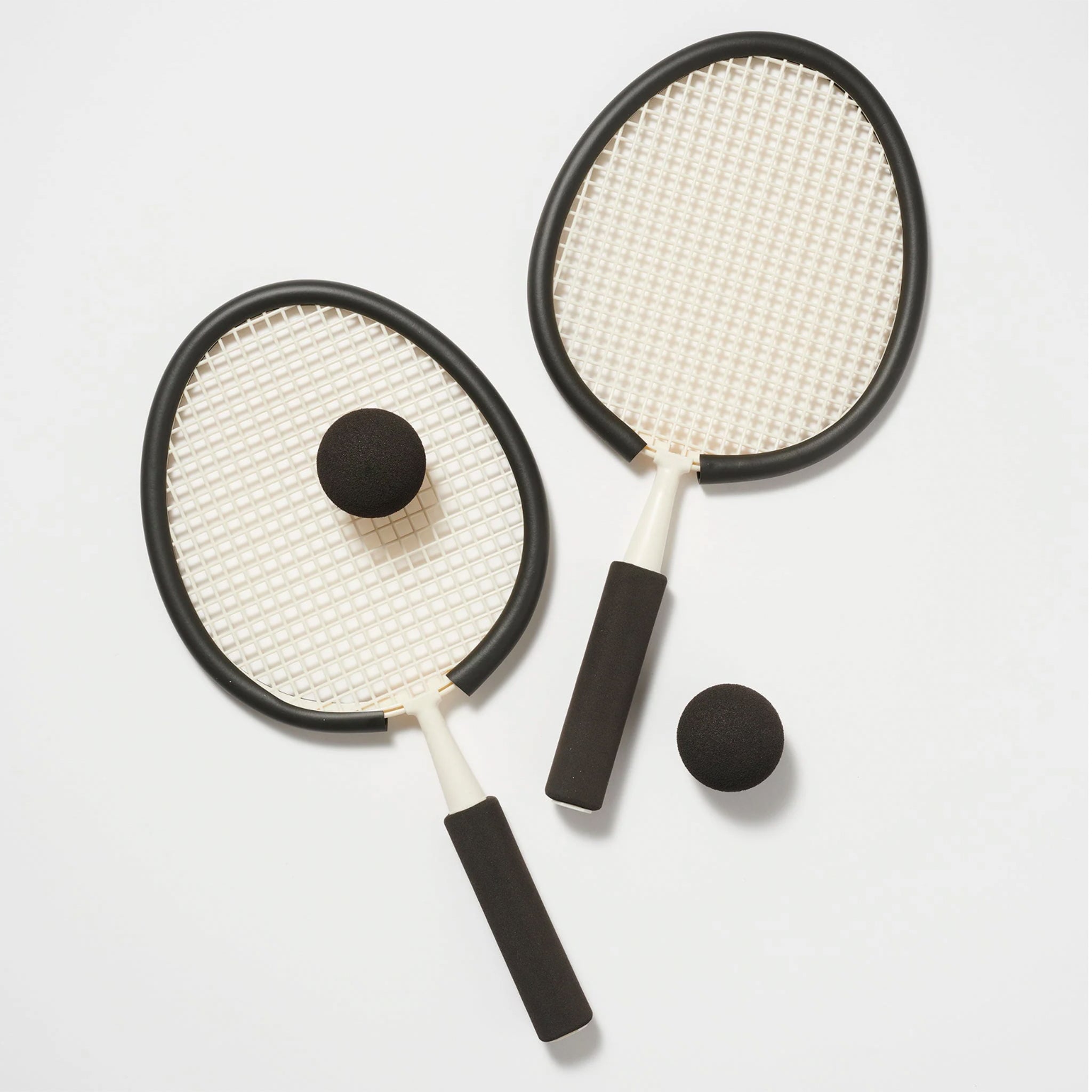 On a white background is two rackets with two balls. 