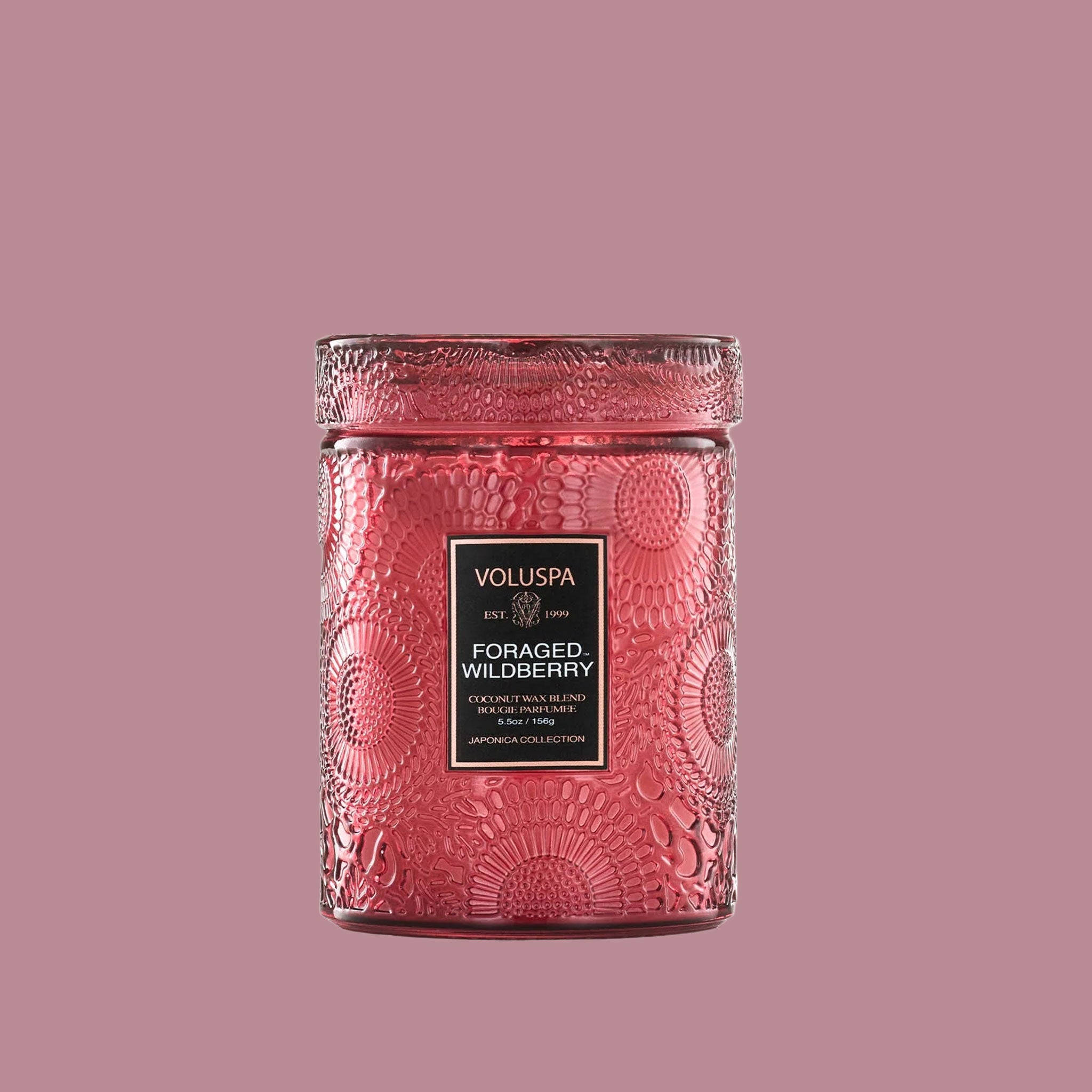 A red decorative glass jar candle with a matching lid. 