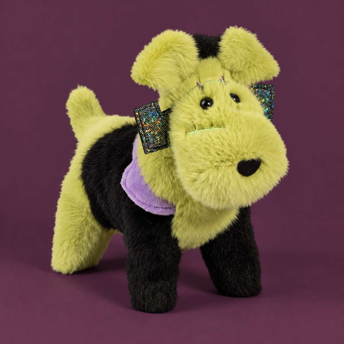 A plush dog toy with yellow and black fur, a purple bandana, and glittery multicolor bow accessories on its ears, set against a solid dark purple background.