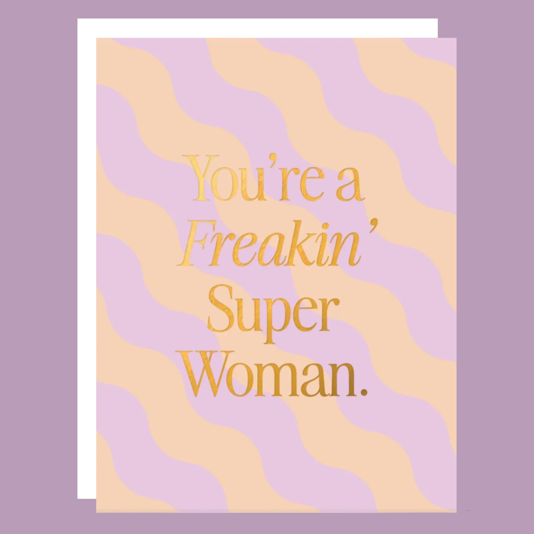 A purple and peach greeting card with a wavy stripe design and gold foiled text that reads, 'You're a Freakin' Super Woman'.