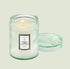 A light green decorative glass jar candle with a white rectangular label that reads, "French Cade Lavender".