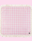 A pink and white checkered picnic blanket with a fringe edge. 