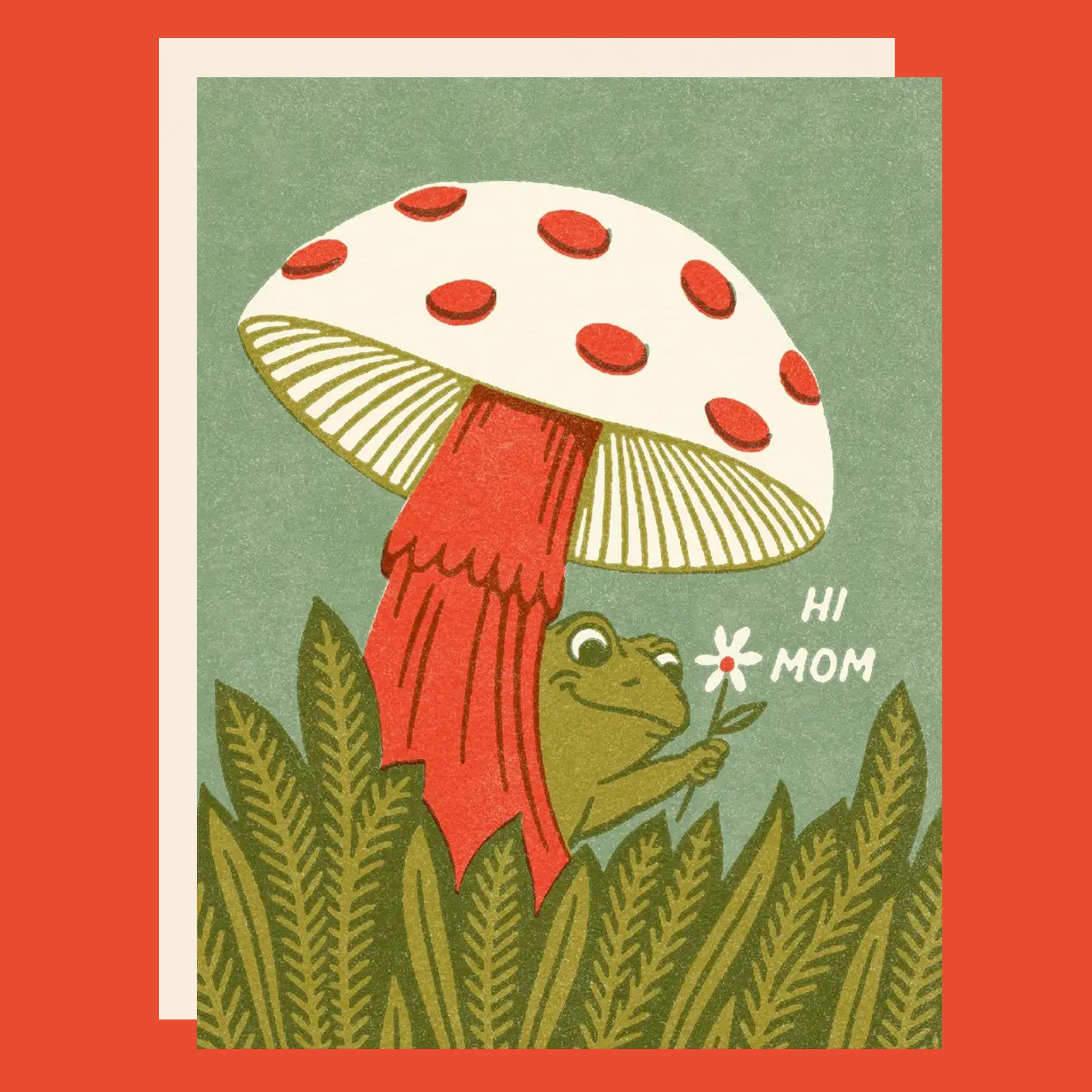 Greeting card with a mushroom and frog, the frog is holding a daisy. The card reads "Hi Mom". 