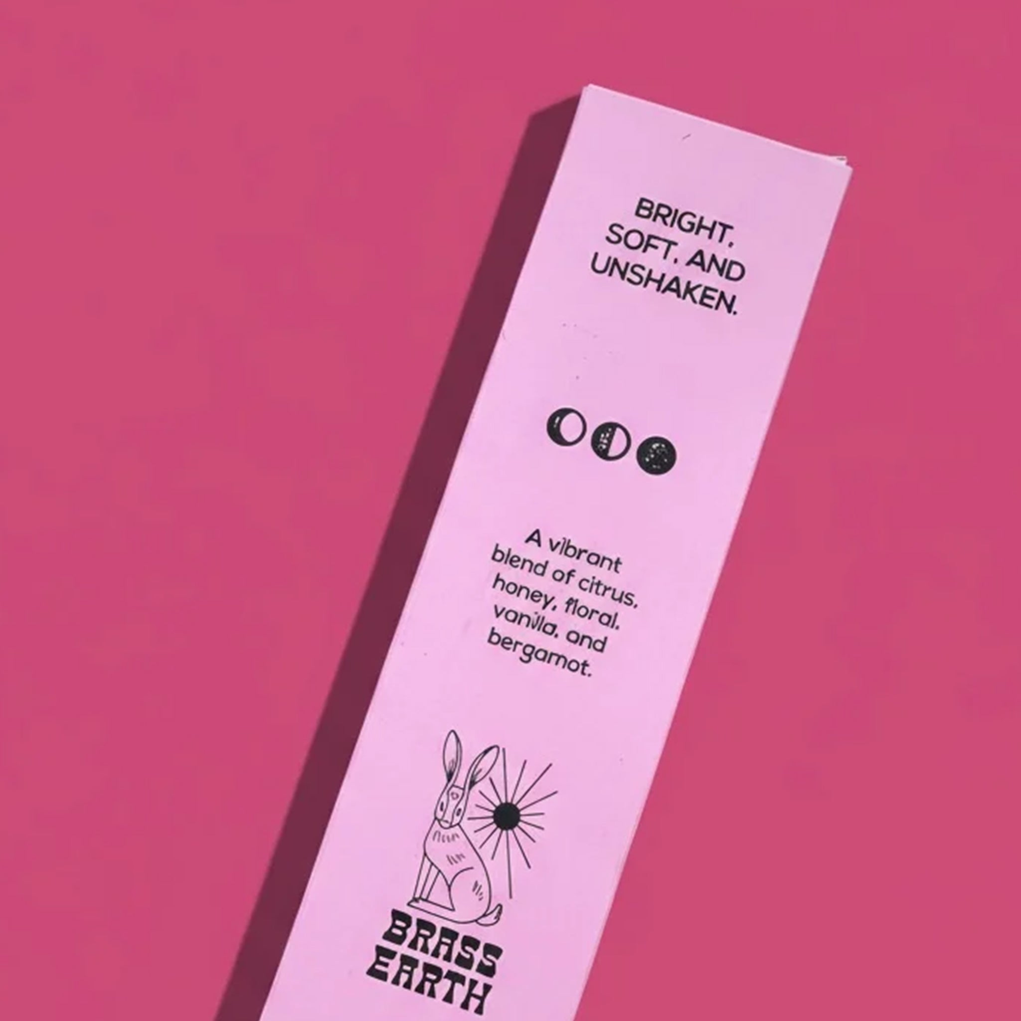 Pink product packaging with black text and branding on a pink background