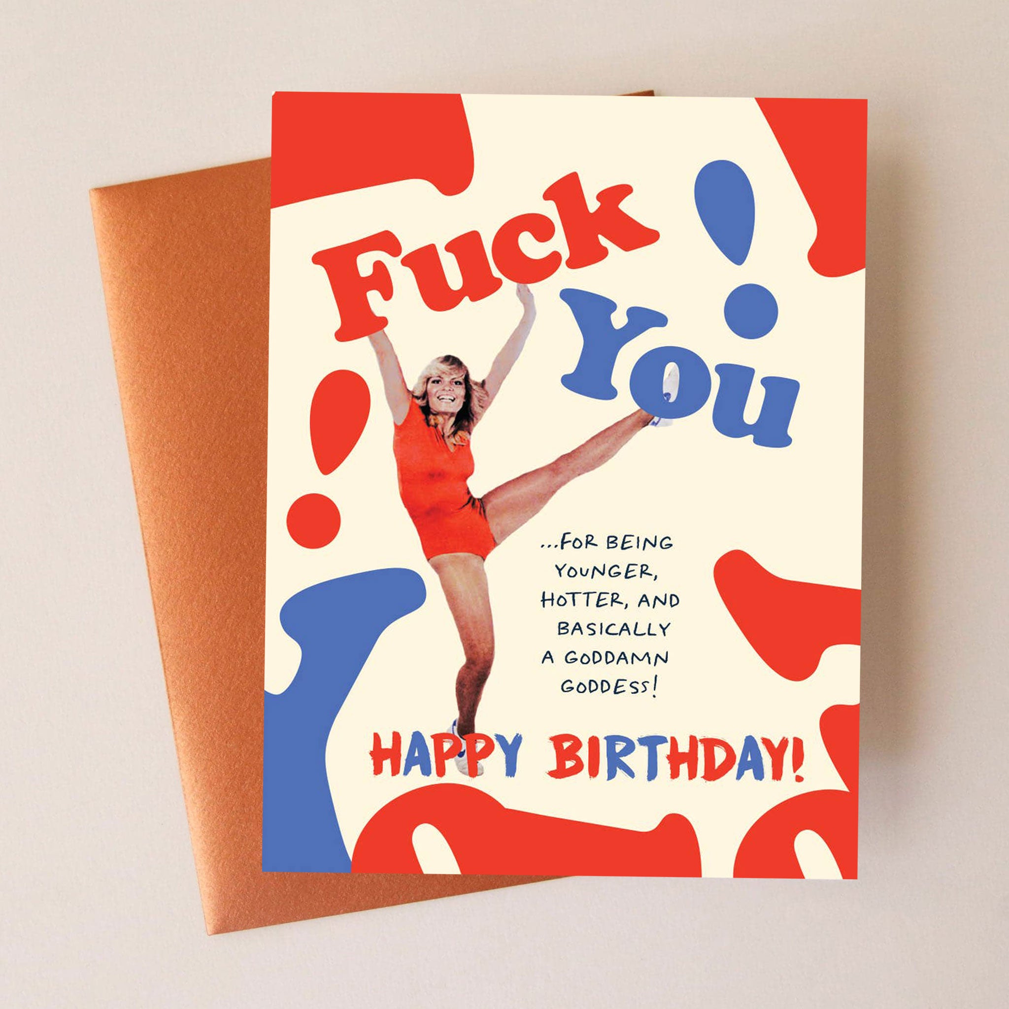 On a neutral background is a red white and blue card with a girl doing a high kick along with text that says, "Fuck You! ....For Being Younger, Hotter,  and Basically A Goddamn Goddess! Happy Birthday". 