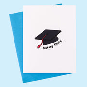 A white card with a graphic of a black graduation cap and text underneath that says, "Fucking Finally" along with a blue envelope. 