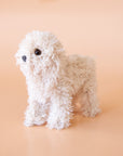 A cream furry poodle ornament with a gold loop for hanging.