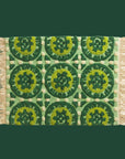 A green patterned bath mat with fringe edges. 