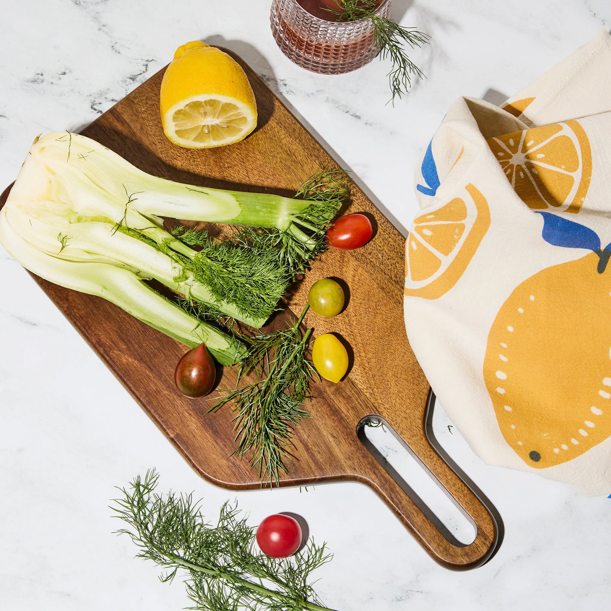 A wood cutting board / cheese board and a gold knife. 