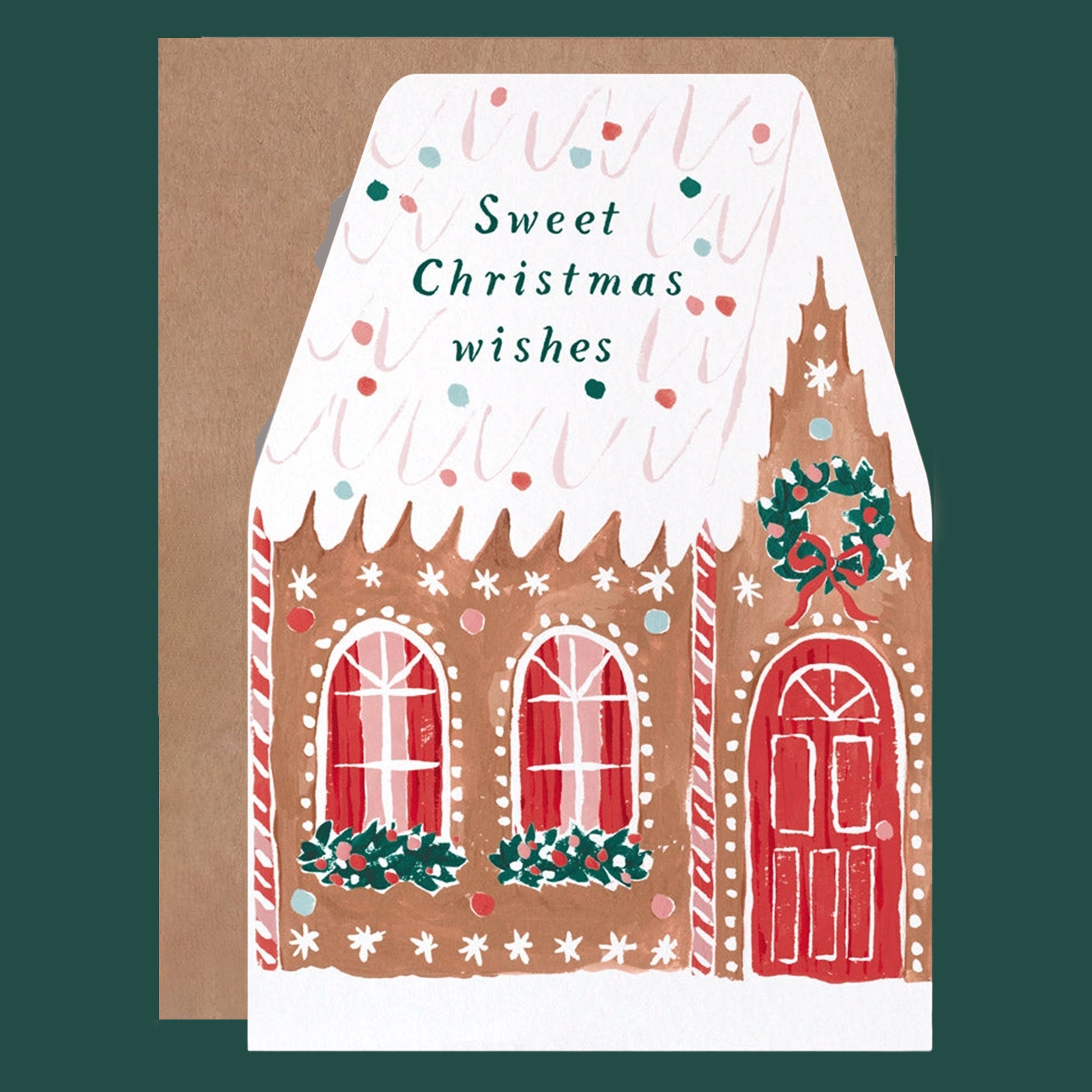 Gingerbread house card with festive details that reads "Sweet Christmas Wishes" on the roof. 