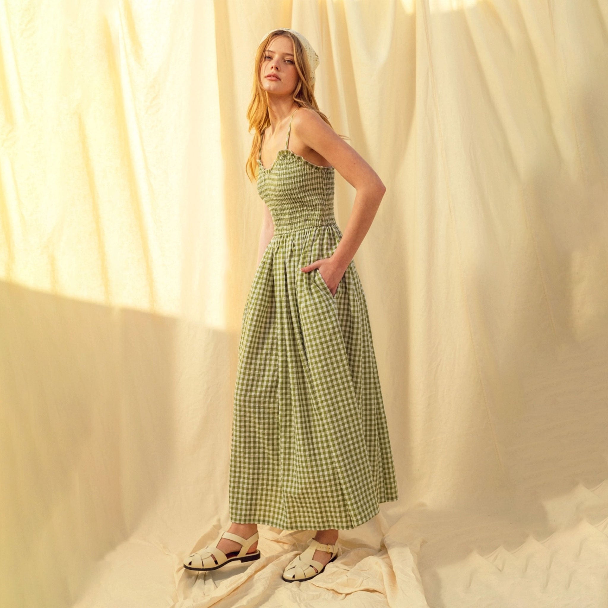 A green and white gingham print maxi dress with spaghetti straps. 