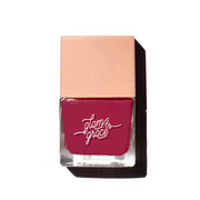 On a white background is a square nail polish bottle with a plum red shade inside. 