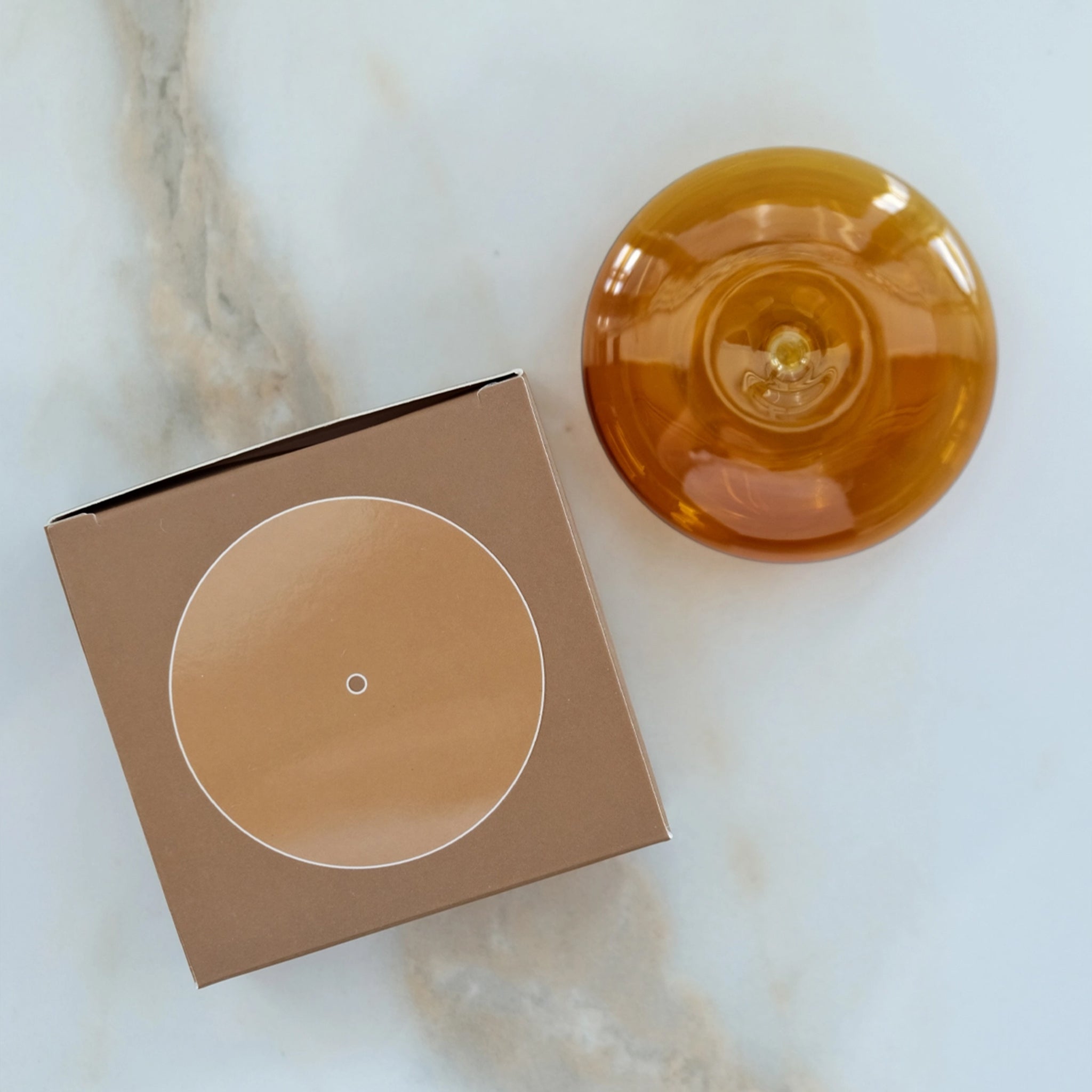 An amber colored glass bubble incense holder. Incense not included. 