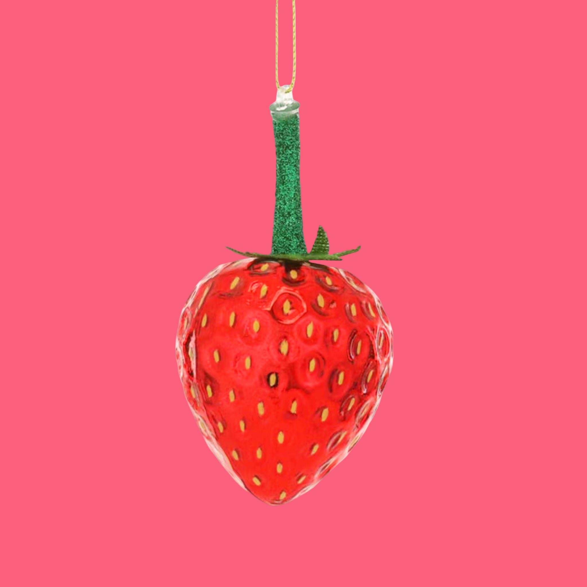 A glass strawberry shaped christmas ornament.