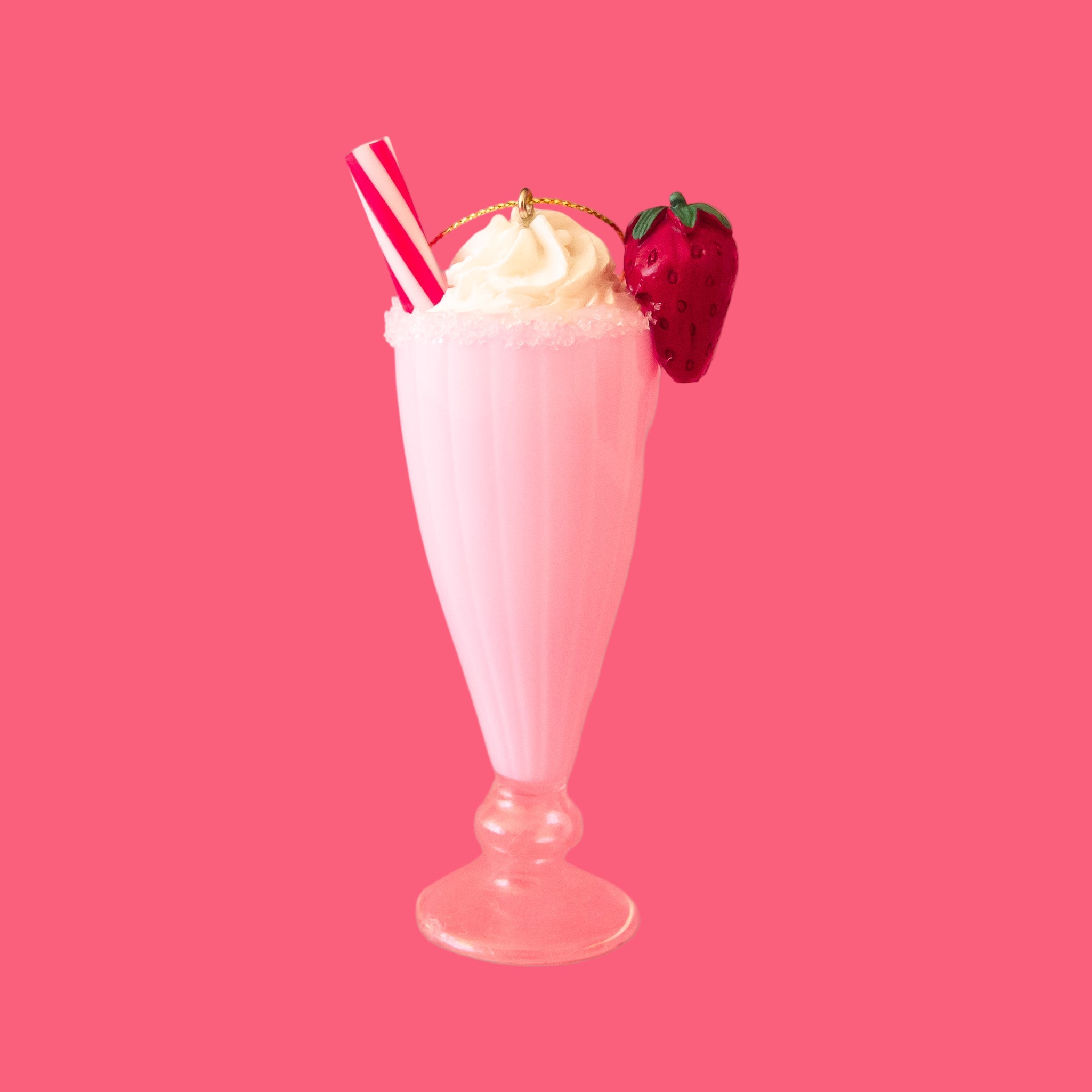 A pink milkshake shaped ornament with a red and white straw and a red strawberry garnish. 