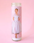 A thin pink prayer candle with a photo of Ariana Grande in a pink dress. 