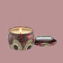 A red tin with a single wick candle inside and a label on the lid that reads, "Voluspa Goji Torocco Orange".