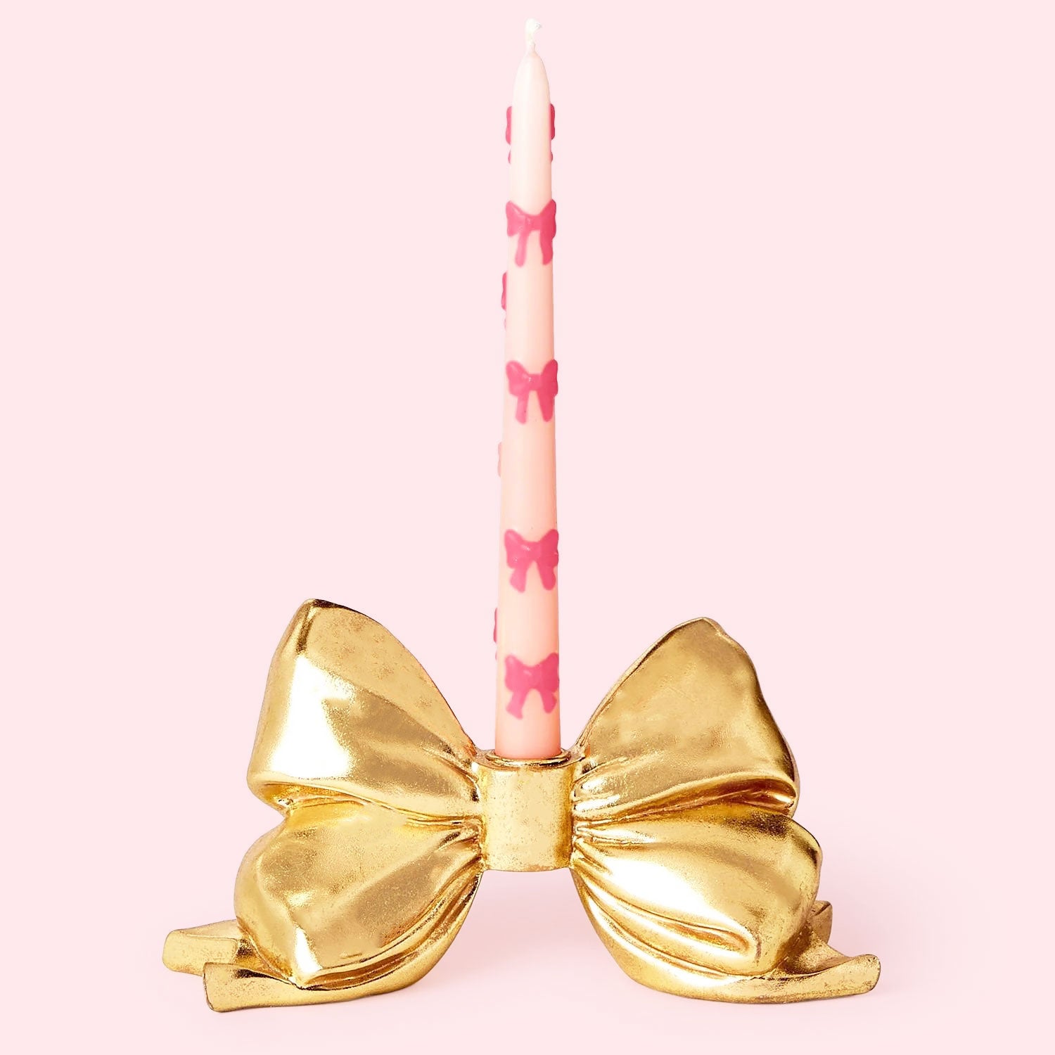 A gold bow shaped taper candle holder. 