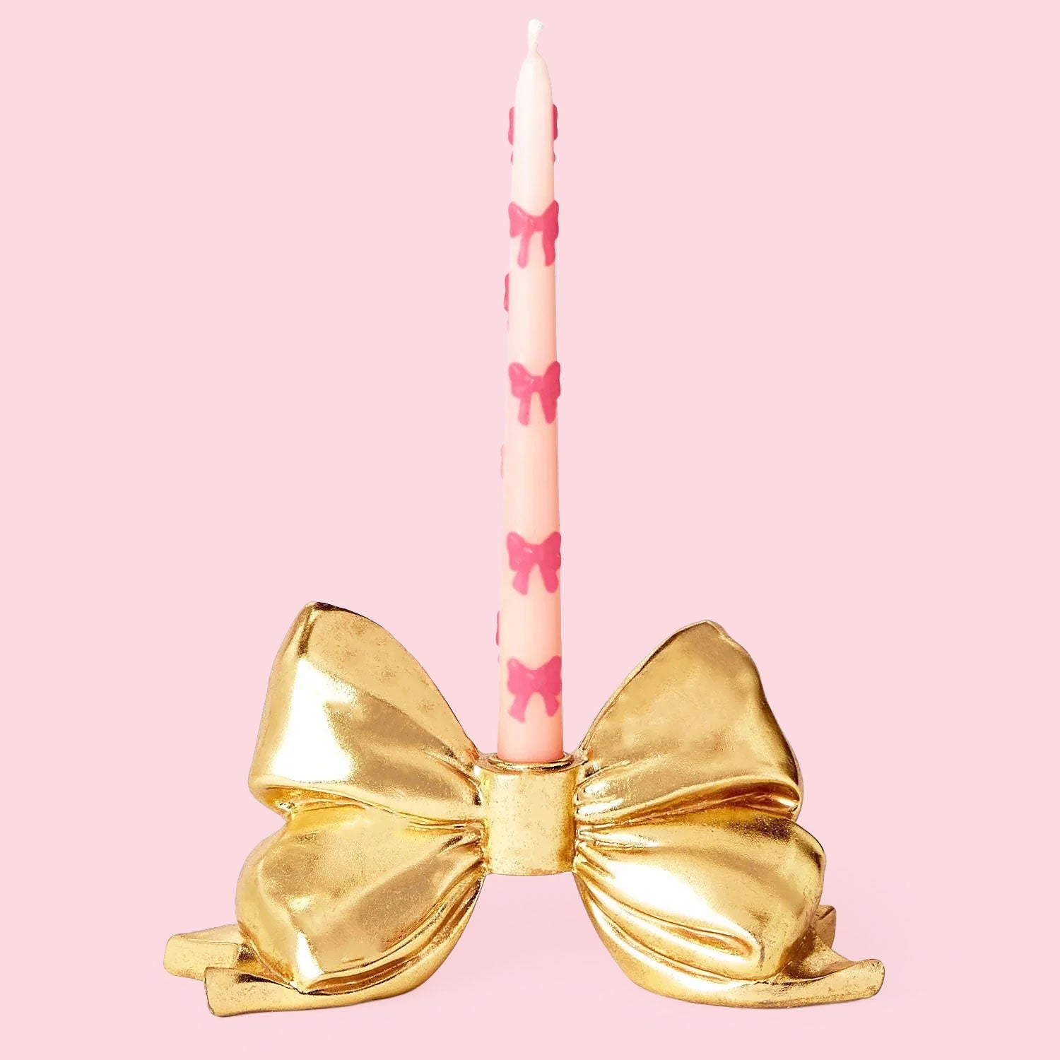 A gold bow shaped taper candle holder. 