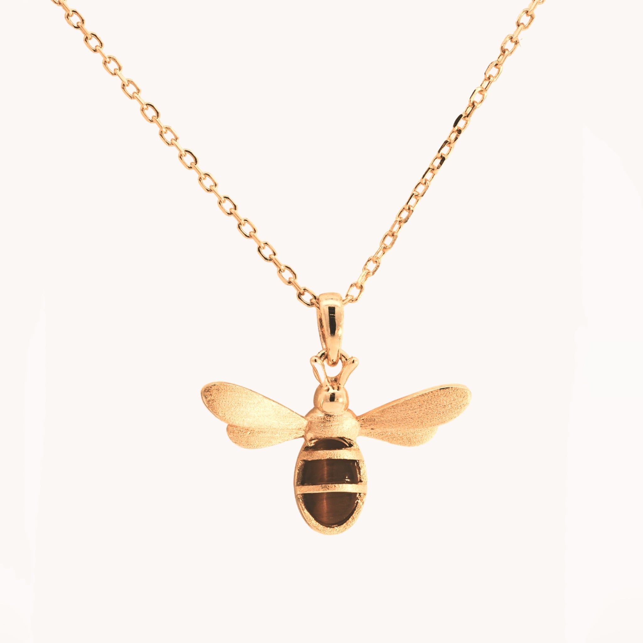 A gold bee pendant necklace. 