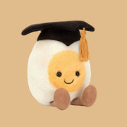 Toy resembling a boiled egg with a graduation cap on a white background