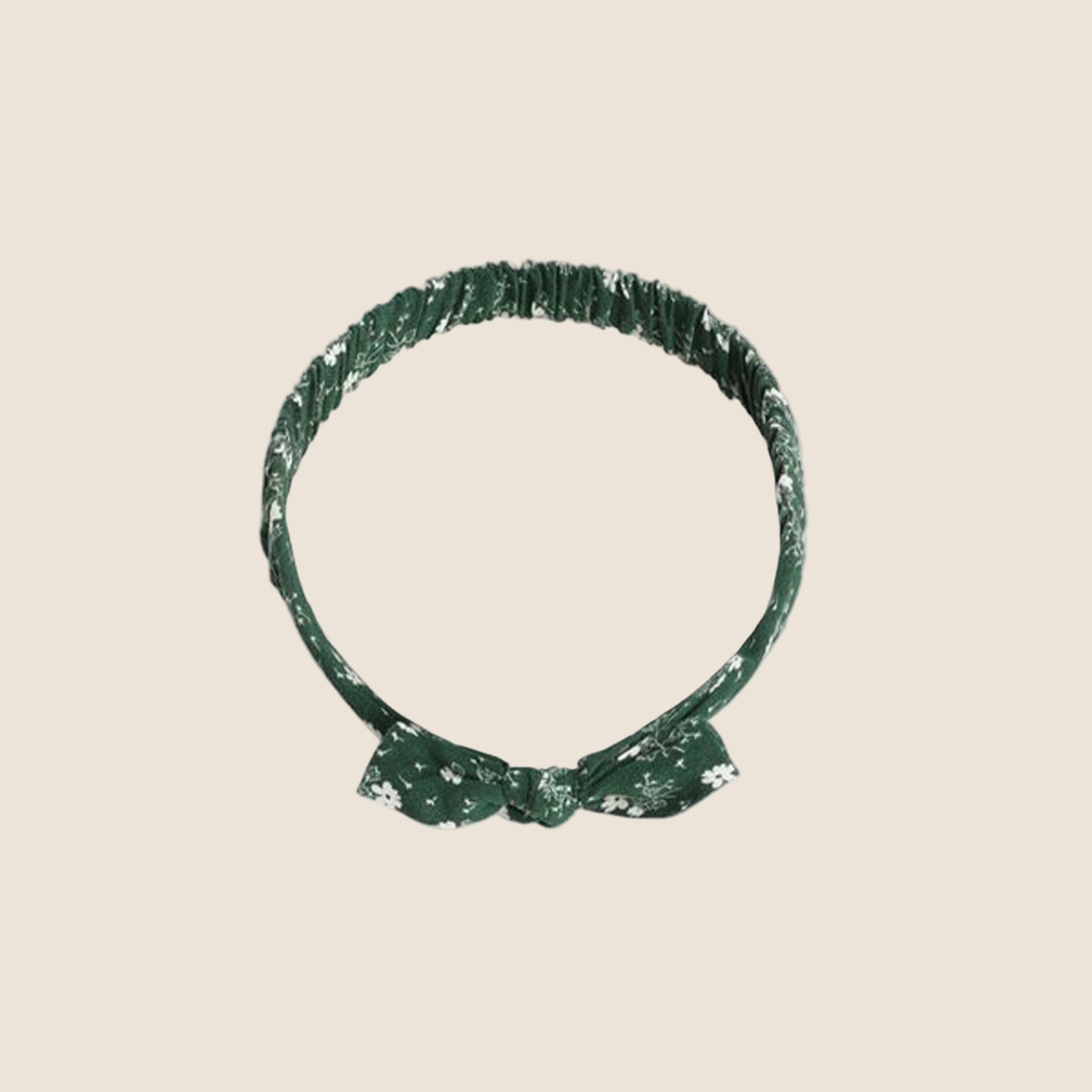 A green baby bow headband with white floral print. 