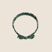 A green baby bow headband with white floral print. 