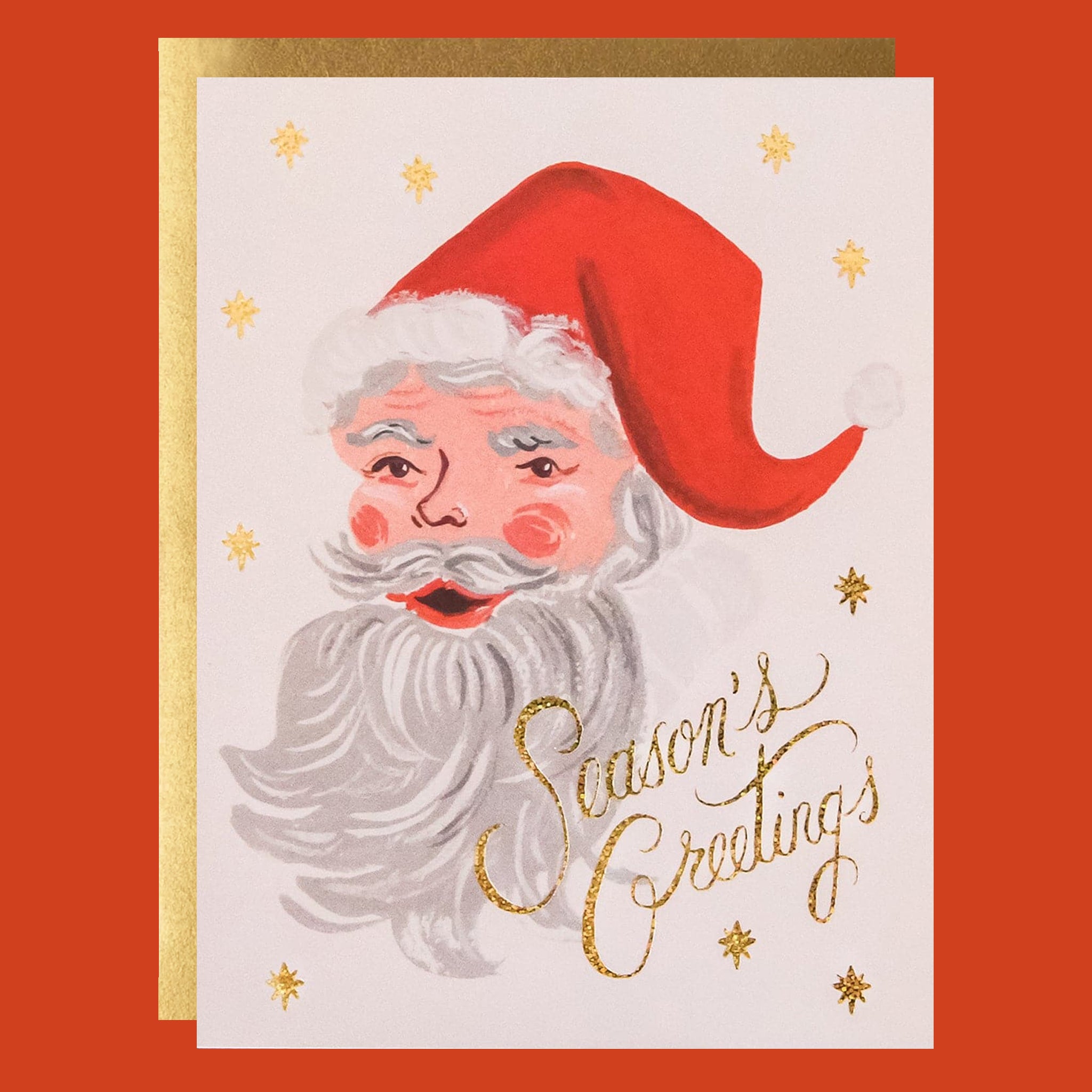 A greeting card with gold stars and a cheerful Santa illustration with a matching gold envelope.